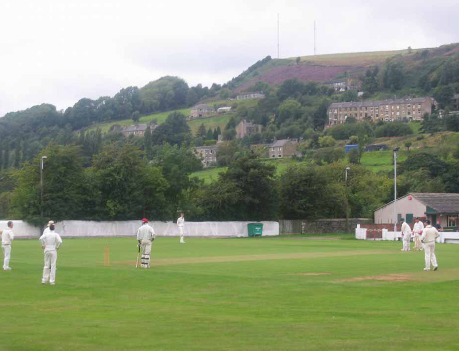 Linthwaite Cricket Club cricket ground in Huddersfield, West Yorkshire, with players enjoying a cricket match.